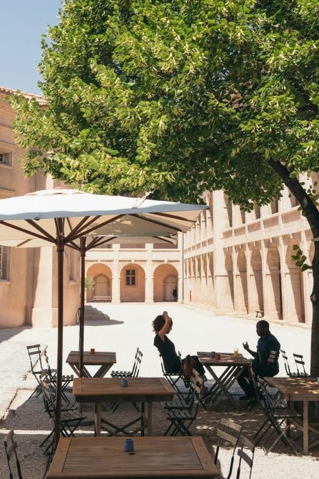 man and woman sitting on chair while dining under patio umbrella man and woman sitting on chair while dining under patio umbrella